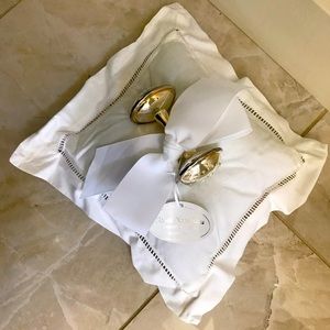 Silver baby rattle on white pillow